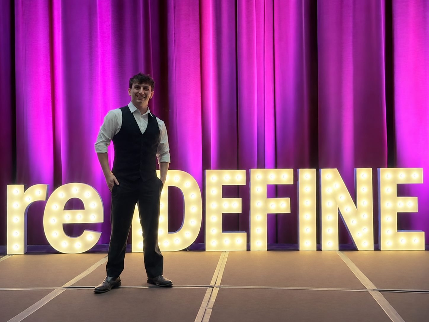 Kristan Catalano in front of the lit reDEFINE sign